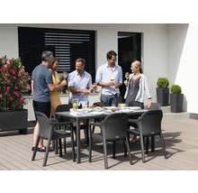 Gruppe von Personen, die an einem Gartentisch mit Glasplatte und Stühlen sitzen
