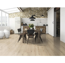 Heller Raum mit Holzboden, Holztisch mit Stühlen und Küchenzeile im Hintergrund