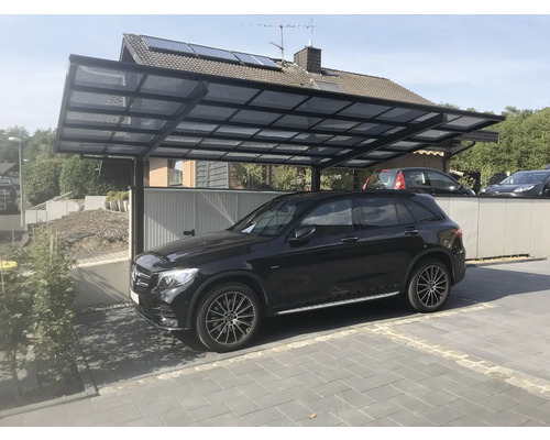 Ein Carport aus Metall mit einem schwarzen Auto darunter