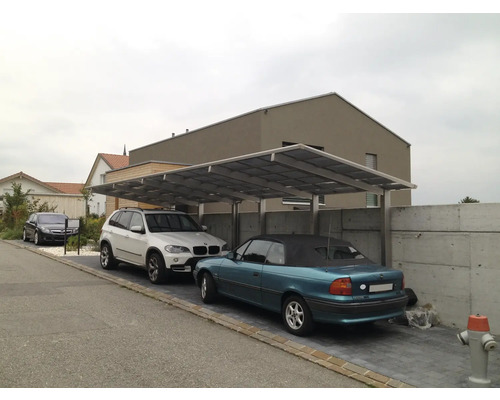 Drei Autos unter einem Carport auf einem Wohngrundstück.