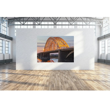 Ein Foto einer Brücke hängt an einer Wand in einem Raum.