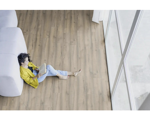 Helle, freundliche Raumszene mit Holzboden und einer Frau, die ein Buch liest