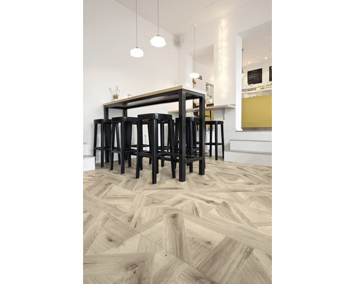 Innenraum mit Holzboden in geometrischem Muster, Bartisch und Barhockern.