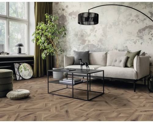 Wohnzimmer mit Sofa, Tisch, Zimmerpflanze und Holzboden in Fischgrätmuster