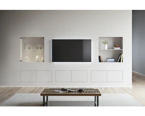 Helle Wohnzimmereinrichtung mit TV, Regalen und einem Couchtisch.