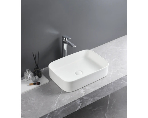 Rechteckiges Aufsatzwaschbecken aus Keramik mit Armatur auf einer Marmorplatte