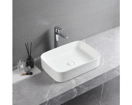 Rechteckiges Aufsatzwaschbecken aus Keramik mit Armatur auf einer Arbeitsplatte