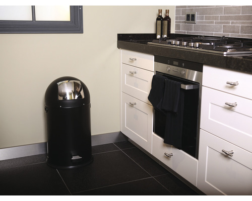 Küchenszene mit einem schwarzen Treteimer und weißen Küchenschränken