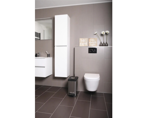 Modernes Badezimmer mit Toilette, Waschbeckenunterschrank, Spiegelschrank, Hochschrank, Treteimer und Dekoration