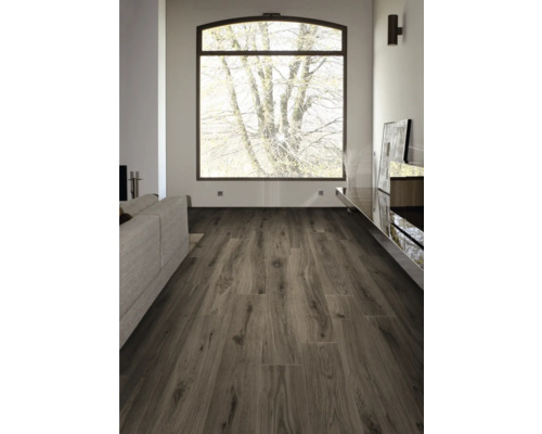 Wohnzimmer mit Sofa, Fenster und Laminatboden in Holzoptik.