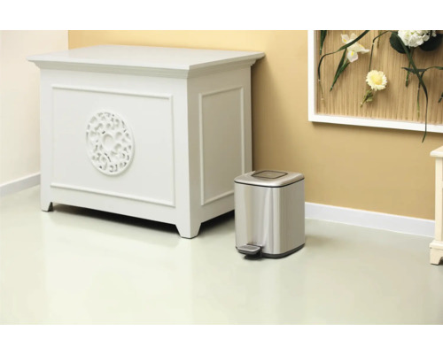 Szene mit Kommode und silberfarbenem Treteimer