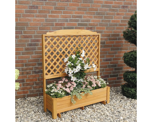 Blumenkasten mit Rankgitter und Bepflanzung vor einer Ziegelwand