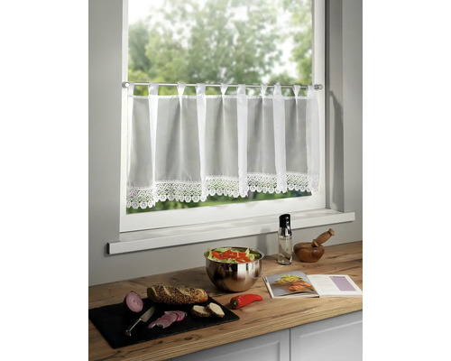 Gardinenstore am Fenster über einer Küchentheke mit Zutaten