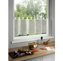 Gardinenstore vor einem Fenster, dazu Zutaten für eine Mahlzeit auf einer Küchentheke