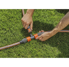 Gartenbewässerungsszene mit T-Stück und Schlauchverbindungen auf Rasen