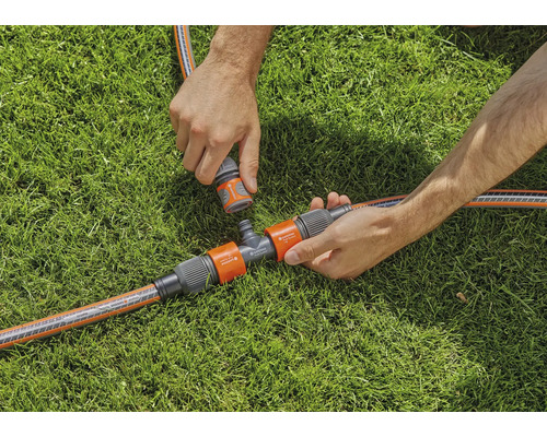 Gartenbewässerungsszene mit T-Stück und Schlauchverbindungen auf Rasen