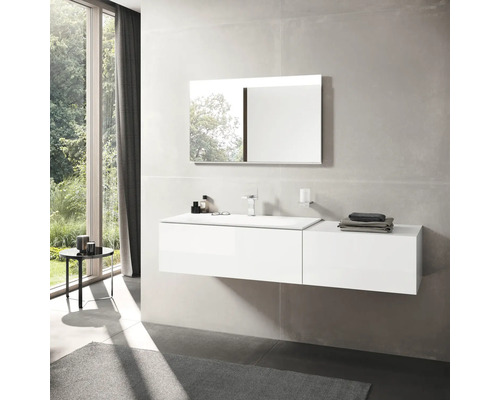 Helles Badezimmer mit Waschtisch, Spiegel und Fenster.