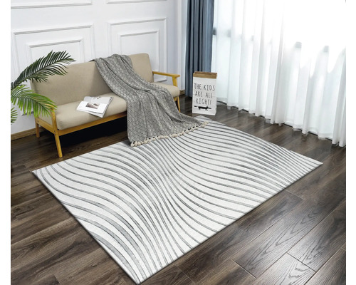 Wohnzimmer mit Sofa, Decke und Teppich mit Linienmuster auf Holzboden