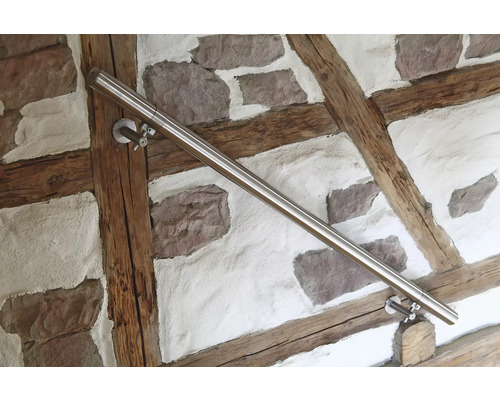 Edelstahlhandlauf an einer Wand mit Stein- und Holzelementen