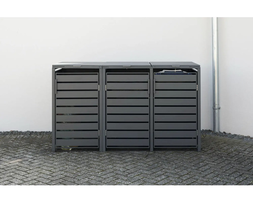 Drei graue Mülltonnenboxen mit Lamellenstruktur vor einer weißen Wand.