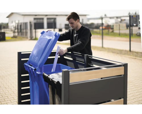 Mann öffnet blaue Mülltonne in einer Mülltonnenbox