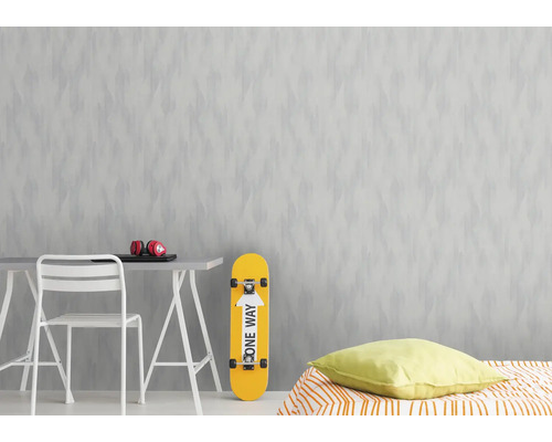 Zimmer mit gemusterter Tapete, Tisch, Stuhl, Skateboard und Bett