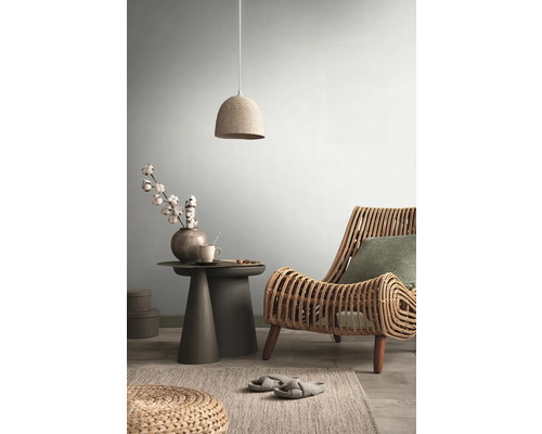 Wohnzimmer mit Rattansessel, Beistelltisch und Hängelampe für eine helle, gemütliche Atmosphäre