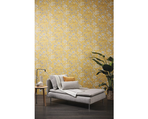 Szene mit einer Liege, einem Beistelltisch und einer floral gemusterten Tapete