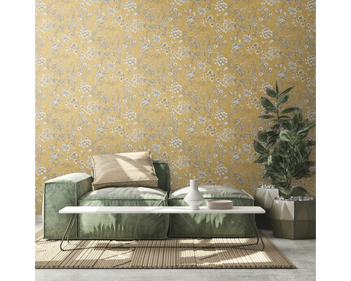 Wohnzimmer mit gelber Blumentapete, Sofa, Tisch und Zimmerpflanze