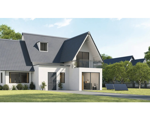 Haus mit Ziegeldach, Balkon und Solarmodulen im Garten