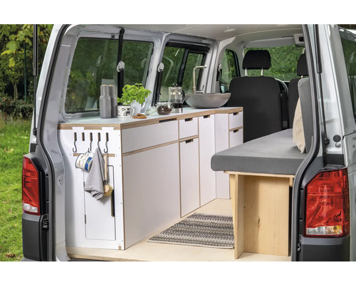 Innenausbau eines Kastenwagens mit Küchenzeile, Spüle und Bett.