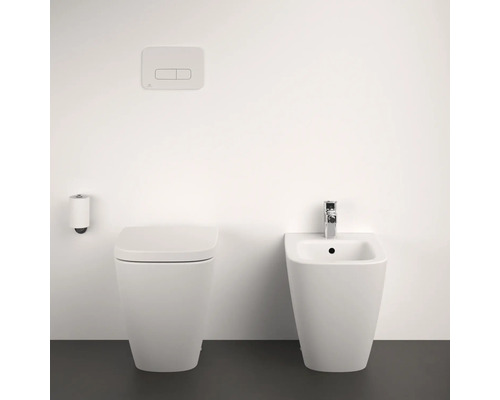 Toilette, Bidet und Betätigungsplatte in einem hellen Badezimmer