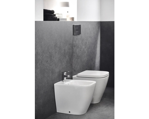 Bidet und Toilette im Badezimmer mit grauer Wand