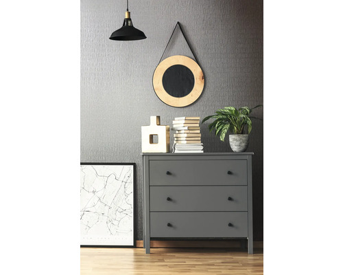 Graue Kommode mit drei Schubladen, Lampe, Spiegel, Dekorationen und Pflanzen in einem Zimmer