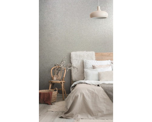 Schlafzimmer mit Bett, Lampe, Stuhl und gemusterter Tapete für ein helles und organisiertes Ambiente.