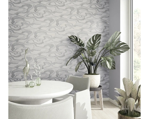 Heller Raum mit Esstisch, Stühlen, Zimmerpflanzen und gemusterter Tapete