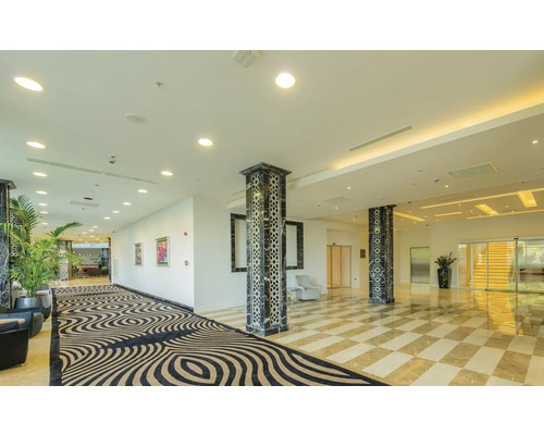 Heller Empfangsbereich mit Schachbrettmusterboden, Säulen und Teppich mit Muster