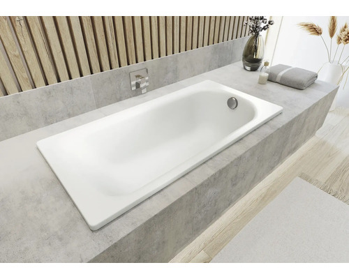 Eingebaute Badewanne in einem hellen Badezimmer mit Holzelementen und grauen Fliesen.