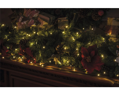 Dekorativer Weihnachtsschmuck mit Lichtern, Geschenken, Tannenzweigen und Weihnachtssternen.