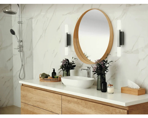 Helles Badezimmer mit Waschtisch, rundem Spiegel, Armaturen und Dusche.