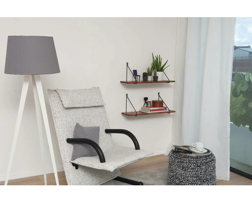 Wohnzimmer mit Stehlampe, Sessel und Wandregalen