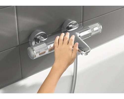 Aufputz-Brausebatterie mit Kinderhand im Badezimmer
