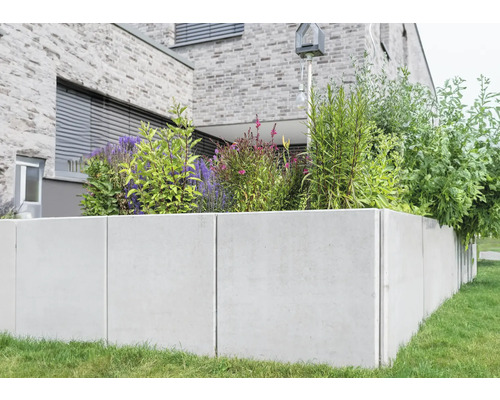 Hochbeet aus Beton mit Pflanzen vor einem Haus