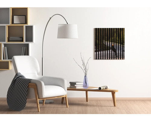 Wohnzimmer mit Sessel, Stehlampe, Tisch und Wandbild mit Skateboardfahrer