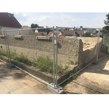 Baustelle mit Bauzaun und beschädigter Mauer