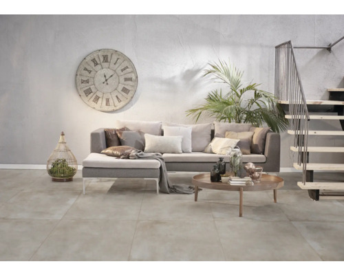 Wohnzimmer mit Sofa, Uhr, Treppe und Fliesenboden