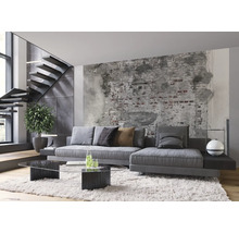 Wohnzimmer mit grauer Couch, Couchtisch aus Glas und Treppe