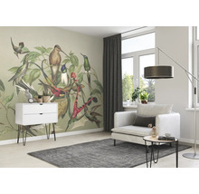Helles Wohnzimmer mit einer Wandtapete mit Vogelmotiv, einem weißen Schrank, einem Sessel und einem grauen Teppich.