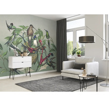 Helles Wohnzimmer mit einer Wandtapete mit Kolibris, einem weißen Sessel und einem grauen Teppich.