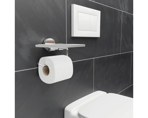 Toilettenpapierhalter mit Ablage an einer gefliesten Wand